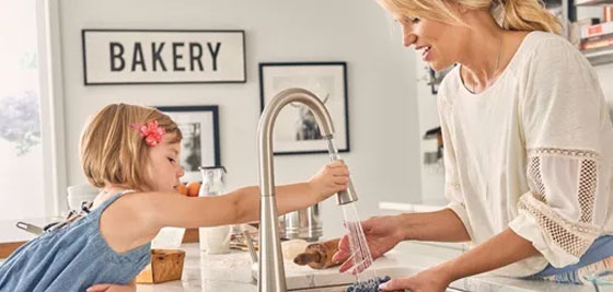 Daughter and Mom in Kitchen using Moen Faucet