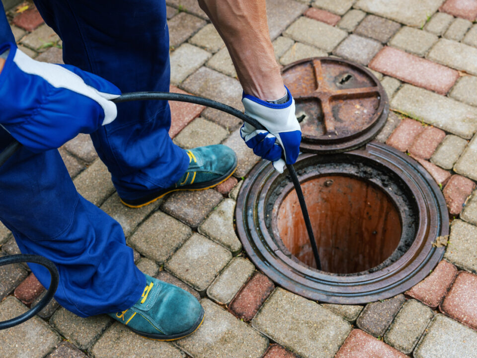 sewer cleaning service worker clean a clogged drainage with hydro jetting